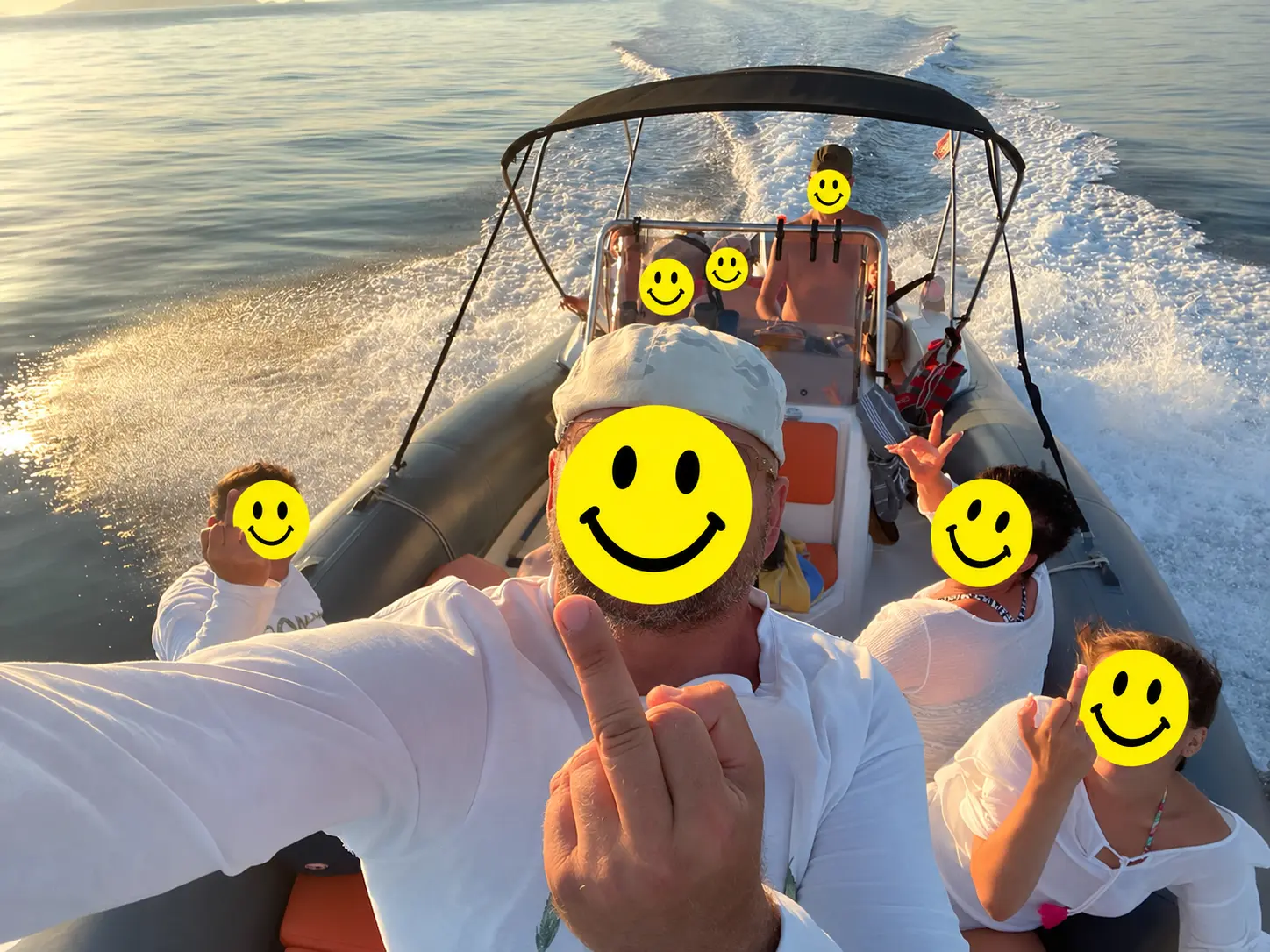 Gäste auf einem Boot bei Sonnenuntergang, Gesichter mit Smileys verdeckt